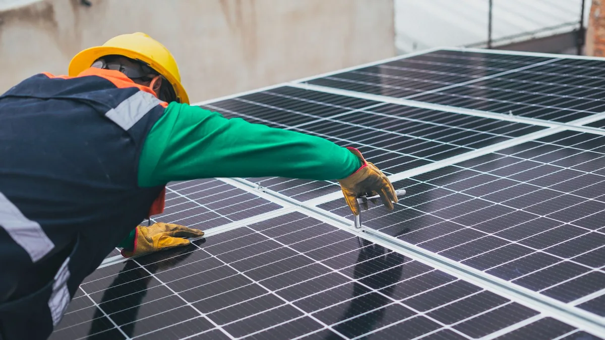 Installers mounting solar panels on a house roof in Winston-Salem, NC